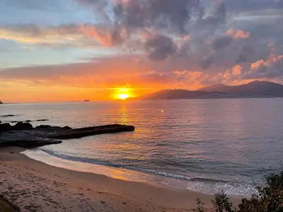 a sunset on the beach with the sun setting at Villa vue sur mer Corse Blanca Casa à PORTICCIO AJACCIO in Grosseto-Prugna