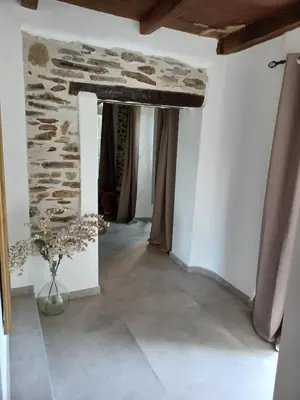 four different views of a living room with a stone wall at Casa Pernice in Penta-di-Casinca