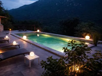 a swimming pool at night with chairs around it at Casa Stella in Olmeto