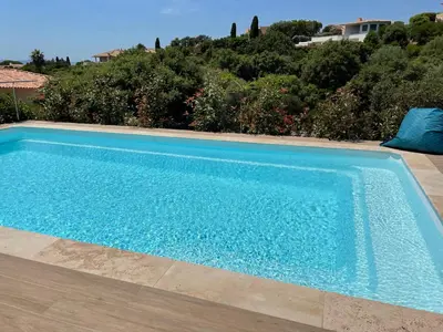 a large blue swimming pool in a yard at Villa Bianca in Zonza