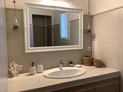a bathroom with a white sink and a mirror at Villa AZURA, vue panoramique et proche mer à Santa Giulia, piscine chauffée in Porto-Vecchio