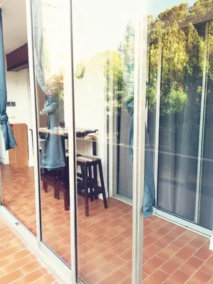 a screened in porch with a table and a dining room at Appartement Ajaccio Sanguinaires in Ajaccio