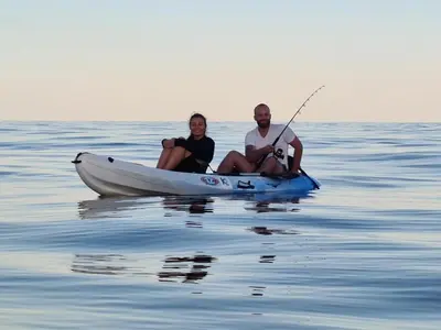 a man and woman sitting in a boat on the water at Pinea Mare in Poggio-Mezzana