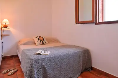 a small bedroom with a bed with shoes on it at Pinea Mare in Poggio-Mezzana