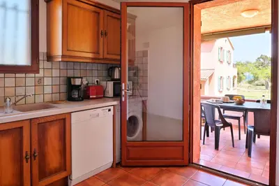 a kitchen with a door open to a dining room at Pinea Mare in Poggio-Mezzana