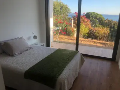 a bedroom with a bed and a large window at Ajaccio appartement 4 couchages, climatisé a 150m de la plage route des sanguinaires, parking privé in Ajaccio