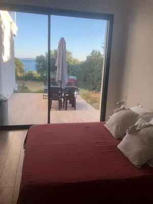 a bedroom with a bed and a view of a patio at Ajaccio appartement 4 couchages, climatisé a 150m de la plage route des sanguinaires, parking privé in Ajaccio