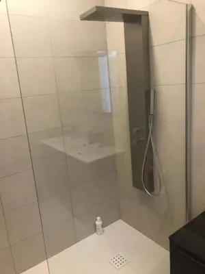 a shower with a glass door and a sink at Ajaccio appartement 4 couchages, climatisé a 150m de la plage route des sanguinaires, parking privé in Ajaccio