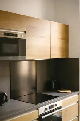 a kitchen with stainless steel appliances and wooden cabinets at Bon'appart in Ajaccio