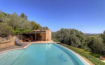 a swimming pool in front of a house at Appartement vue mer en Résidence avec piscine in Porto-Vecchio