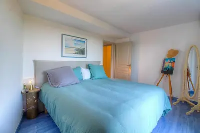 a bedroom with a large bed with blue sheets at Appartement vue mer en Résidence avec piscine in Porto-Vecchio