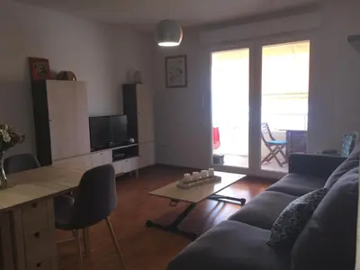 a living room with a couch and a table at Appartement T3 classé 3 étoiles vue mer avec terrasse ,plage 2 minutes à pied in Ajaccio