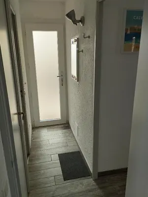 a hallway with a door and a tile floor at Appartement T2 Porticcio Vue sur Mer in Porticcio
