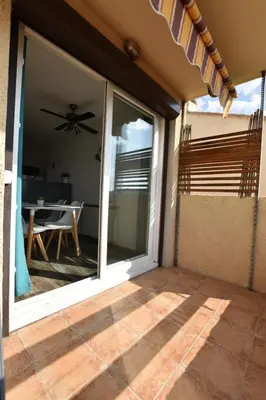 a sliding glass door to a patio with a table at Appartement T2 Porticcio Vue sur Mer in Porticcio
