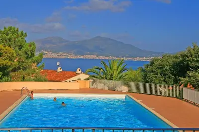 a large swimming pool with a view of the water at Appartement T2 Porticcio Vue sur Mer in Porticcio