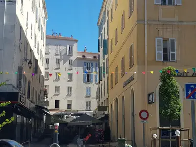 a city street with buildings and flags on the street at AJACCIO CATHEDRALE AU COEUR DE LA CITEE IMPERIALE POUR 3 a 4 PERS PROCHE DES PLUS BELLES PLAGES ET DE TOUTES COMMODITES PORT A 2MN in Ajaccio