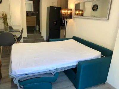 a bed in a room with a table and chairs at Charmant appartement à Ajaccio in Ajaccio