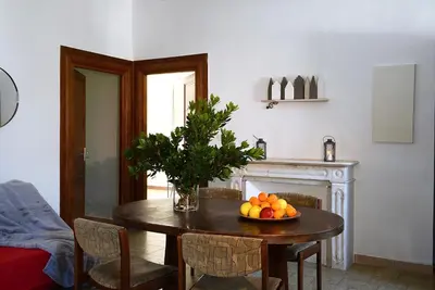 a dining room table with a bowl of fruit on it at Au coeur du Village de Lucciana in Lucciana