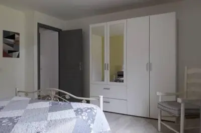 a bedroom with a bed and a cabinet and a chair at Gites Albareddu Conca in Conca