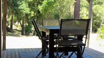 a table and chairs on a porch with a table and a laptop at Gites Albareddu Conca in Conca