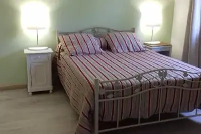 a bedroom with a bed and two night stands with two lamps at Gites Albareddu Conca in Conca