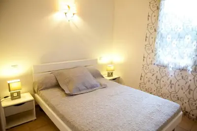 a bedroom with a bed with two lights on it at Locations l'Inzecca in Ghisonaccia
