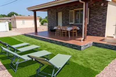 a backyard with a deck and chairs and a table at Locations l'Inzecca in Ghisonaccia