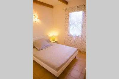 a small bedroom with a bed and a window at Locations l'Inzecca in Ghisonaccia