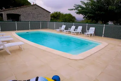 a swimming pool with white chairs at Locations l'Inzecca in Ghisonaccia