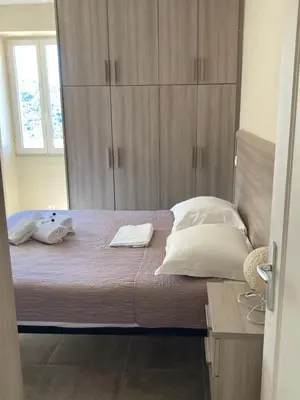 a bedroom with a large bed with wooden cabinets at DUPLEX 4 PERSONNES Clim Wifi Parking in Partinello