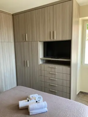 a bedroom with a bed with towels and a tv at DUPLEX 4 PERSONNES Clim Wifi Parking in Partinello