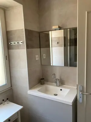 a bathroom with a sink and a mirror at DUPLEX 4 PERSONNES Clim Wifi Parking in Partinello