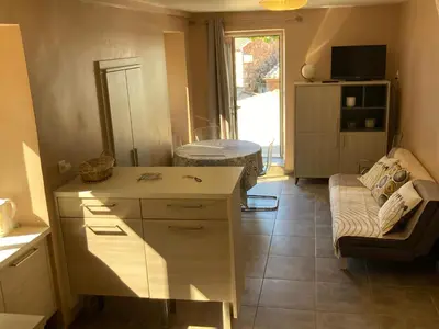 a kitchen with a desk and a couch in a room at DUPLEX 4 PERSONNES Clim Wifi Parking in Partinello