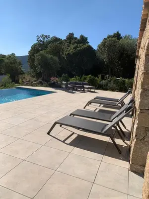 a group of lounge chairs sitting next to a pool at DOMAINE NAPOLEON CORSICA FIGARI in Figari