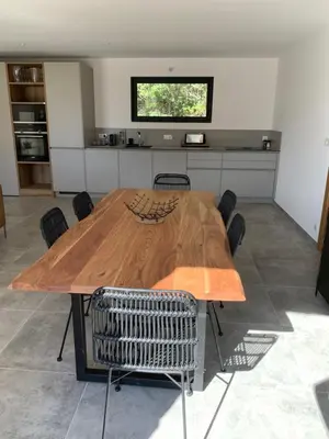 a wooden table in a kitchen with chairs around it at DOMAINE NAPOLEON CORSICA FIGARI in Figari