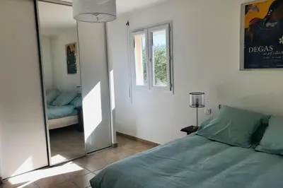 a bedroom with a bed and a large mirror at Bel appartement dans villa à la campagne proche d’Ajaccio in Poggi