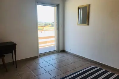 an empty room with a door to a patio at Bel appartement dans villa à la campagne proche d’Ajaccio in Poggi