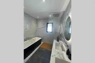 a bathroom with a tub and a sink and a mirror at Villa moderne avec Piscine - Porticcio in Grosseto-Prugna