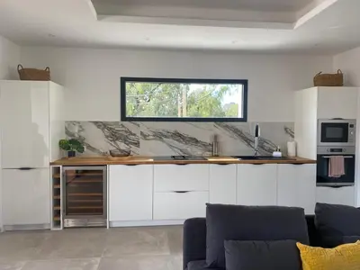 a kitchen with white cabinets and a window on the wall at Villa moderne avec Piscine - Porticcio in Grosseto-Prugna