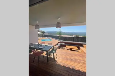 a patio with a table and chairs on a deck at Villa moderne avec Piscine - Porticcio in Grosseto-Prugna