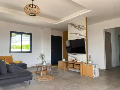 a living room with a couch and a tv at Villa moderne avec Piscine - Porticcio in Grosseto-Prugna