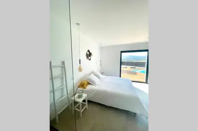 a bedroom with a white bed and a window at Villa moderne avec Piscine - Porticcio in Grosseto-Prugna