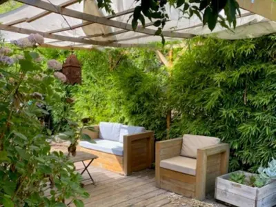 a patio with a couch and a chair under a pergola at Villa Griseor in Porto-Vecchio