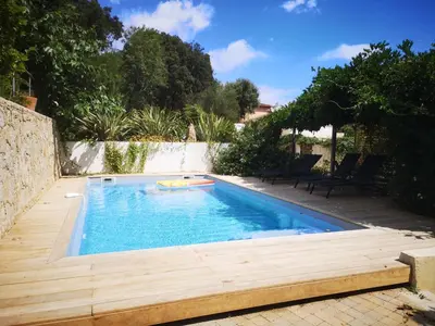a swimming pool in a backyard with a wooden deck at Villa Griseor in Porto-Vecchio