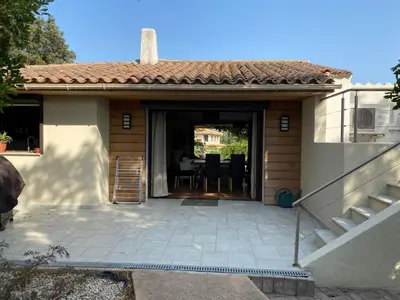 a house with a patio with a table and chairs at Villa Griseor in Porto-Vecchio