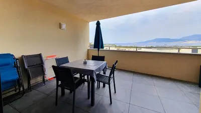 a dining room with a table and chairs and an umbrella at LoCorse - Superbe appartement T2 avec une belle vue mer in Grosseto-Prugna