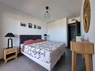 a bedroom with a large bed and a night stand at LoCorse - Superbe appartement T2 avec une belle vue mer in Grosseto-Prugna