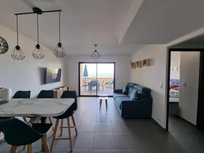 a living room with a blue couch and a table at LoCorse - Superbe appartement T2 avec une belle vue mer in Grosseto-Prugna