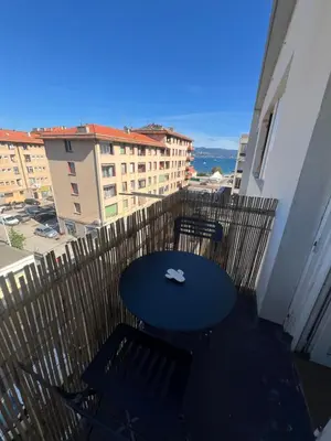 a table and chairs on a balcony with a view at Joli studio spacieux in Ajaccio