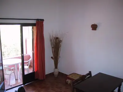 a living room with a table and a vase with branches at Locations A Suara in Porto-Vecchio